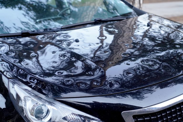 Close up View Of The Hood, Front Pillar, And Part Of The Roof Of A Car Heavily Damaged By Hail. Highlights The Importance Of Covered Parking And Auto Insurance.